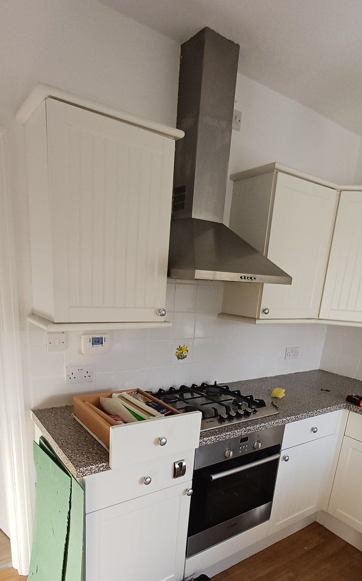A cream shaker kitchen, range cooker and stainless extractor.