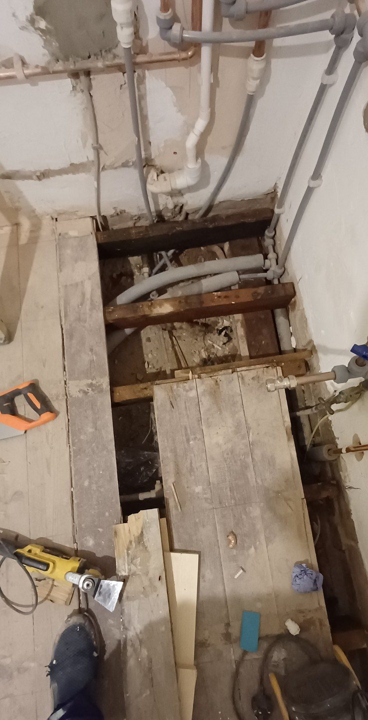 Boards up and joists open. Pipe runs are clipped here so they do not tick when the heating comes on.