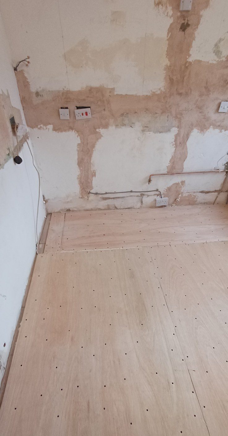 A plywood subfloor cut in and screwed down flat before any finish goes near it.