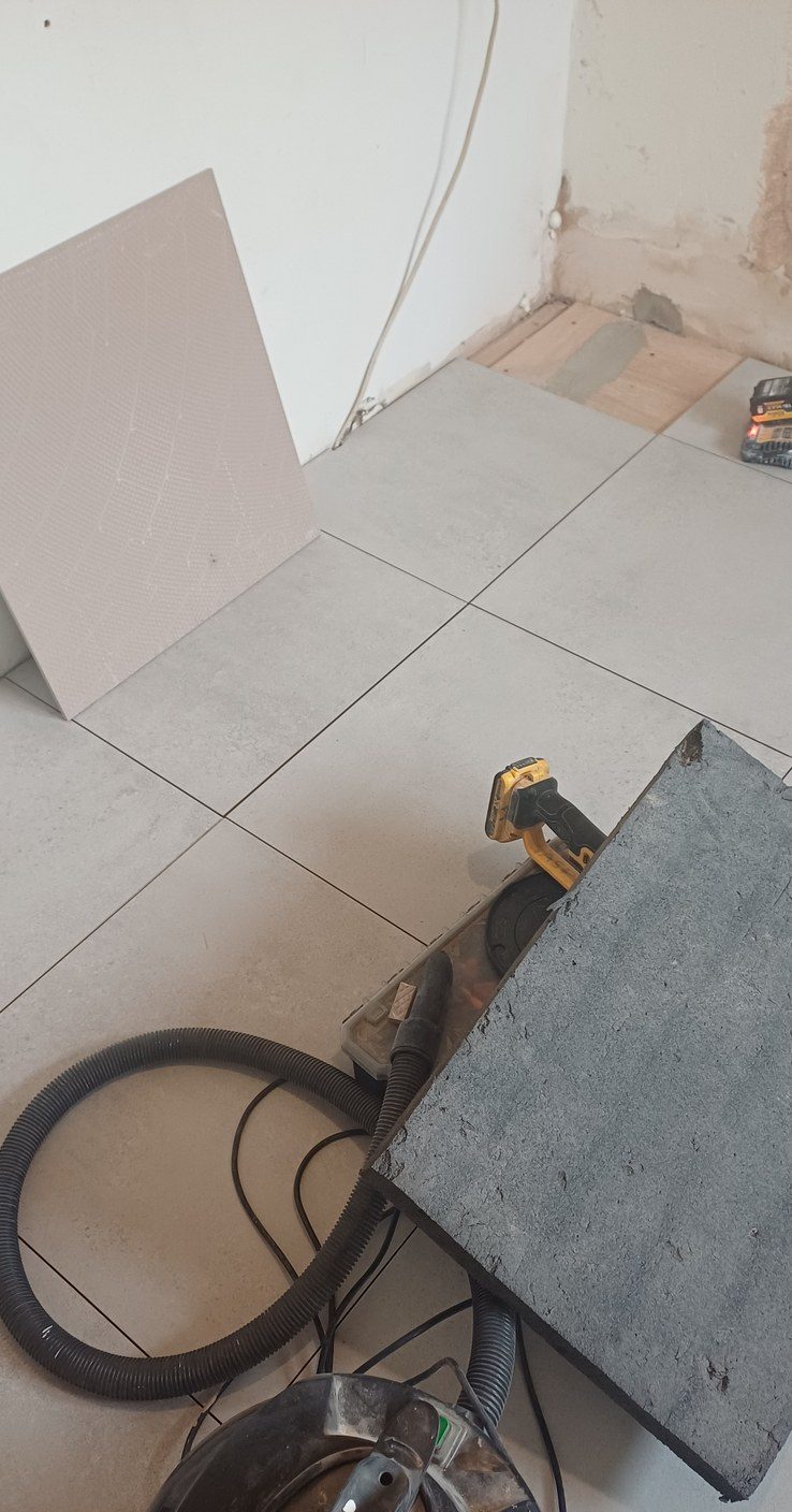 Large-format floor tiles set out dry before any adhesive is mixed.