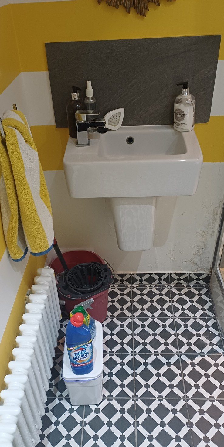 A finished cloakroom floor in patterned tile, cuts kept out of the eyeline.