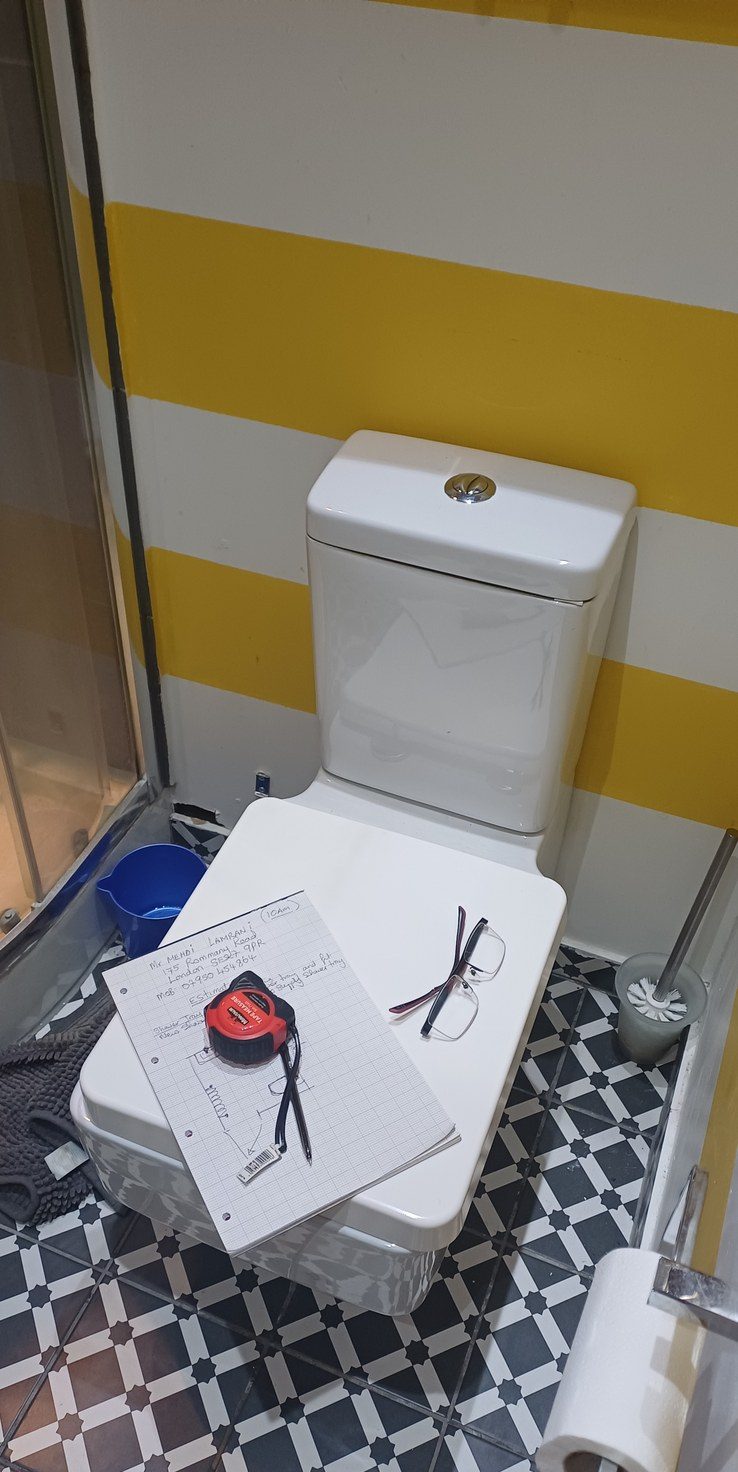 A cloakroom with patterned floor, wall-hung basin and column radiator.
